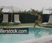 Slow motion shot of family relaxing in outside swimming pool. Boy jumping into the pool and splashing water onto mom and little sister bathing with safety ring. Summer funnLicense this clip: https://videohive.net/item/water-fun-in-the-best-thing-to-do-in-hot-summer/29645643