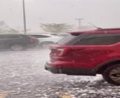 A huge hailstorm struck West Des Moines, Iowa. The large hail falling from the sky damaged all the cars parked in the parking lot.