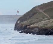 Dramatic footage has been released showing the moment a dog walker was airlifted to safety - after falling into the sea. The man was walking along Cottys Point in Perranporth, Cornwall, when he was cut off by the tide at around 4.30pm on Wednesday (March 27).
